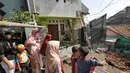 Sejumlah warga melihat kondisi tanah longsor di Perumahan Pesona Kalisari, Pasar Rebo, Jakarta, Selasa (27/11). Belum diketahui total kerugian atas kejadian yang tidak menimbulkan korban jiwa pada Senin (26/11) siang itu. (Liputan6.com/Herman Zakharia)