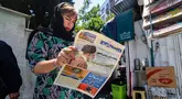 Seorang perempuan membaca surat kabar dengan laporan halaman depan tentang jatuhnya helikopter presiden Iran Ebrahim Raisi di luar kios di Teheran, Senin (20/5/2024). (Atta KENARE / AFP)