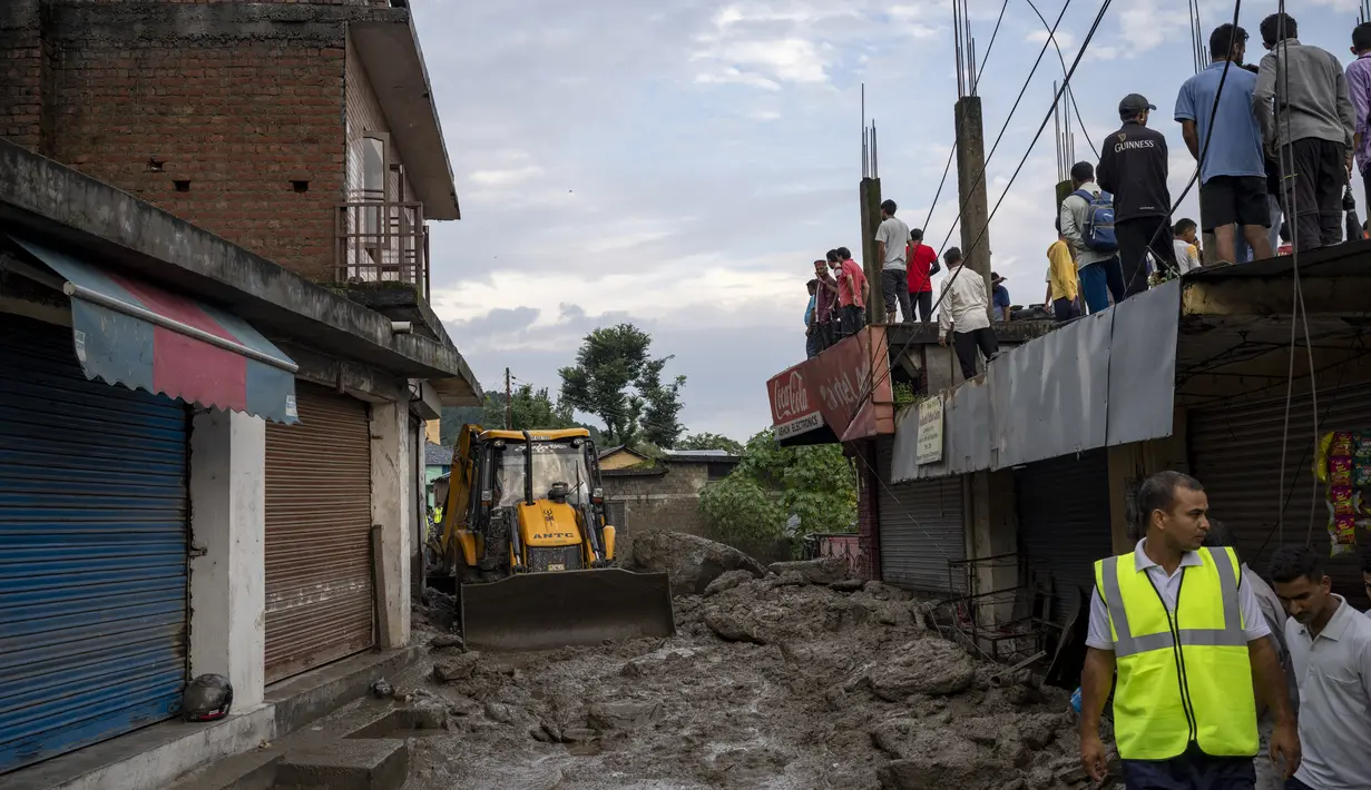 Orang-orang menyaksikan kerusakan yang disebabkan oleh tanah longsor setelah hujan deras di Khaniyara, dekat Dharmsala, India (2/9/2022). Tidak ada korban jiwa yang dilaporkan akibat musibah tersebut. (AP Photo/Ashwini Bhatia)