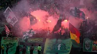 Aksi Bonek saat mendukung Persebaya di dalam stadion. (www.ongisnade.co.id)