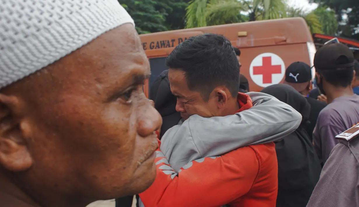 Seorang pria berpelukan sambil menangis setelah gempa bumi di Mamuju, Sulawesi Barat, Indonesia, Jumat (15/1/2021). Gempa ini menyebabkan kerusakan parah pada Hotel Maleo, kantor Gubernur Sulbar, serta RSUD Mamuju. (AP Photo/Azhari Surahman)