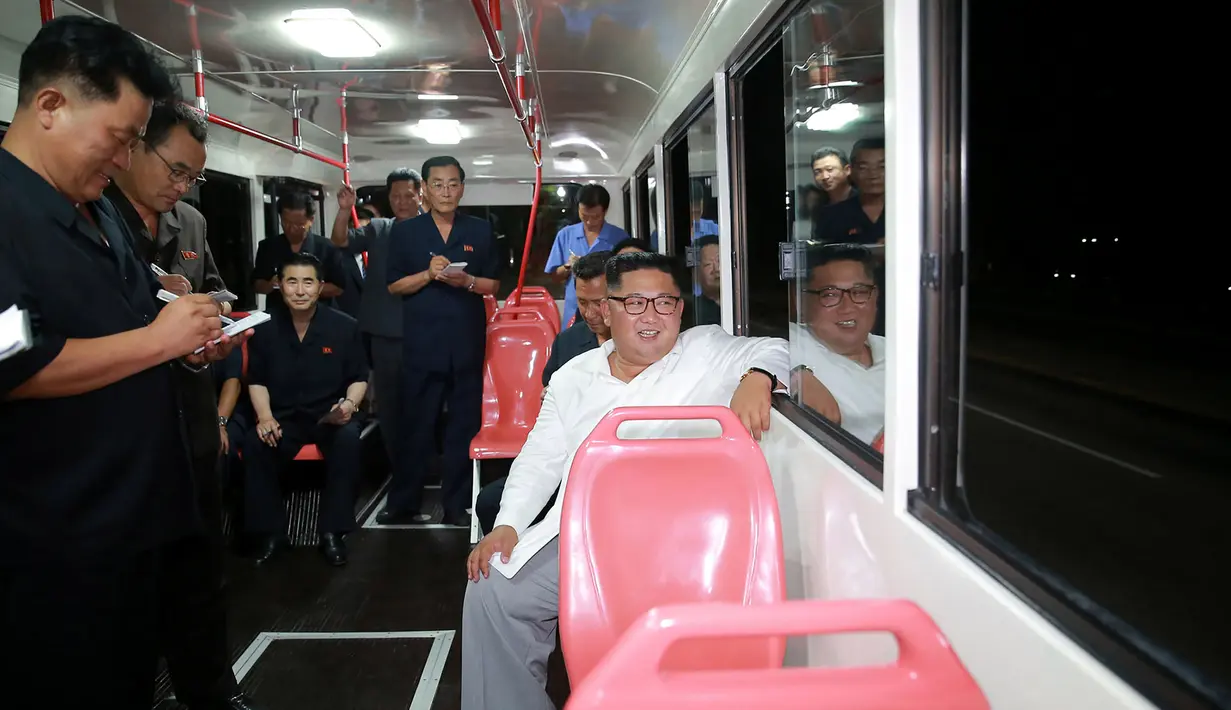 Pemimpin Korea Utara Kim Jong-Un duduk di dalam bus saat menjajal bus jenis baru yang diproduksi selama kunjungan ke pabrik bus di Pyongyang, (4/8). Dalam kunjungannya Kim Jong-un juga menyempatkan diri untuk melakukan 'test-drive'. (AFP Photo/KCNA)