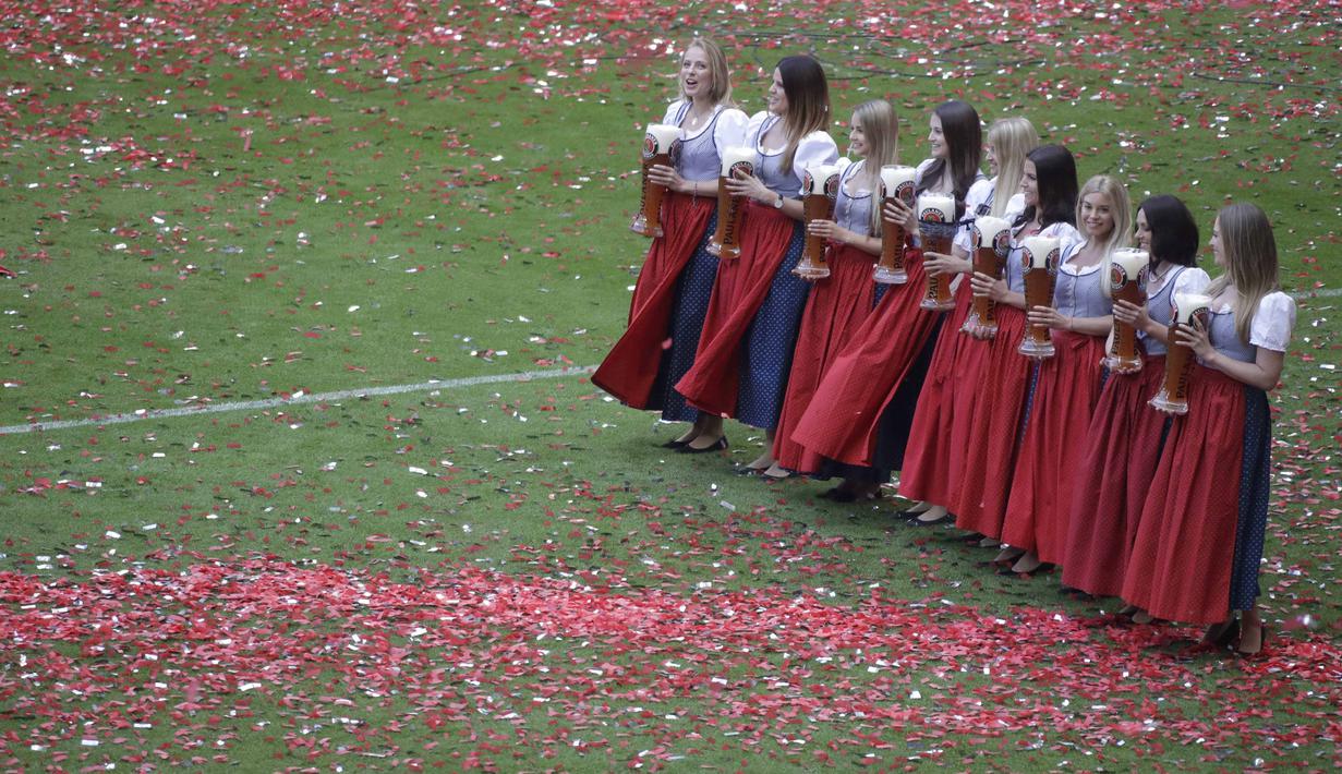 Gadis-gadis muda bersiap menyerahkan bir kepada pemain Bayern Munchen untuk perayaan gelar juara Bundesliga 2016-2017 di Allianz Arena stadium, Munich, (20/5/2017).  Bayern menang 4-1. (AP/Matthias Schrader)