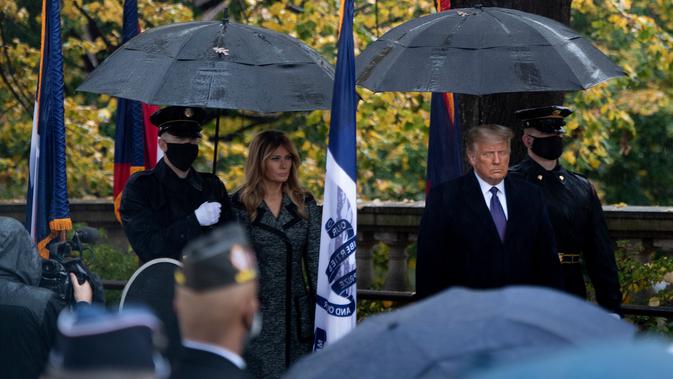 Ibu Negara AS Melania Trump dan Presiden Donald Trump tiba untuk upacara peletakan karangan bunga di Makam Prajurit Tidak Dikenal pada Hari Veteran di Pemakaman Nasional Arlington di Arlington, Virginia, Rabu (11/11/2020). (Brendan Smialowski/AFP)