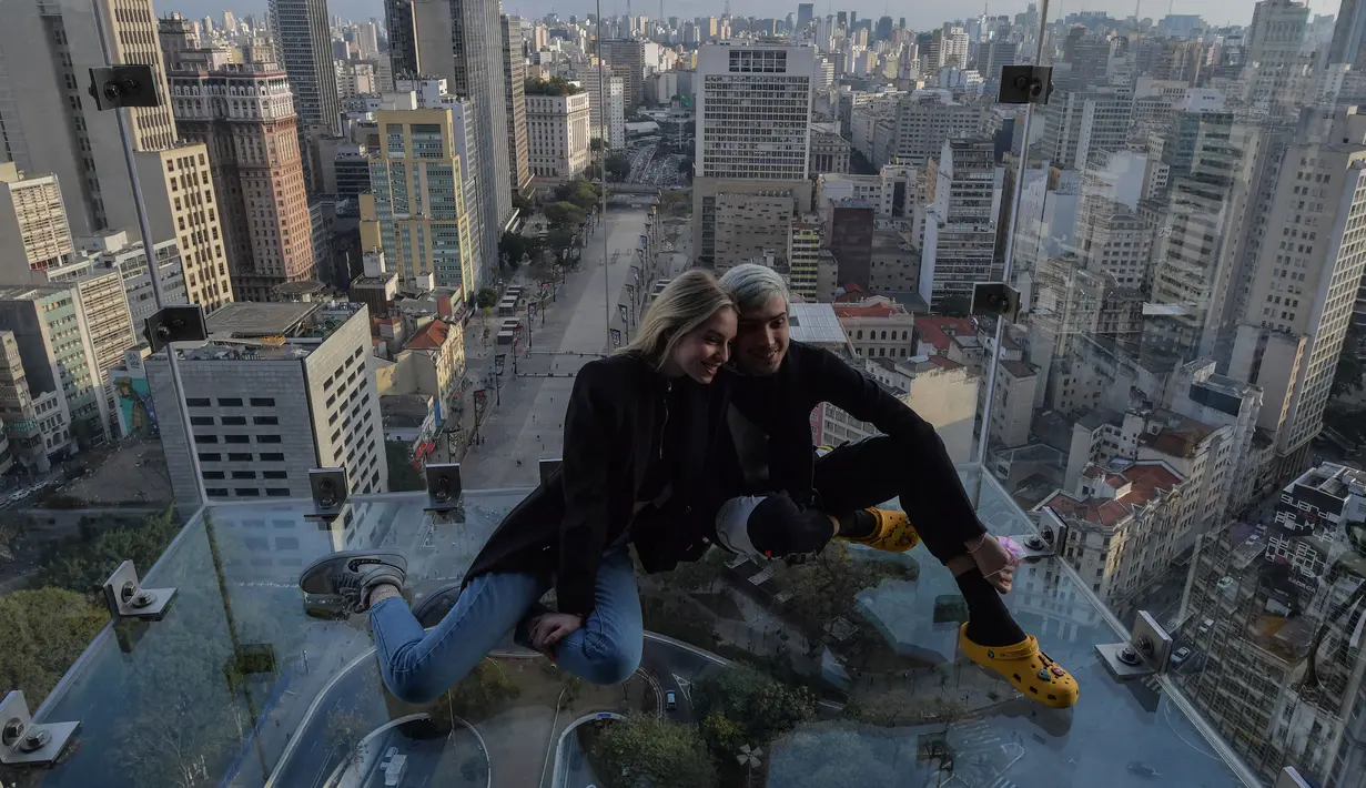 Pengunjung berpose di Sampa Sky Observation Deck di Sao Paulo, Brasil pada 05 Agustus 2021. Di dalam Sampa Sky ini pengunjung daapt melihat keindahan Kota Sao Paulo dari ketinggian. (NELSON ALMEIDA / AFP)