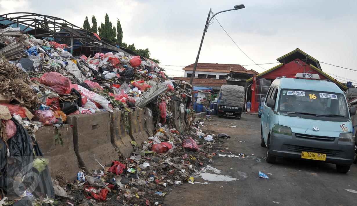 Angkutan umum melintas di samping tempat pembuangan sampah (TPS) di Blok C Pasar Minggu, Jakarta, Minggu (30/4). DPRD DKI meminta pemindahan TPS dekat Lokasi Binaan (Lokbin) Blok C Pasar Minggu dipercepat karena tidak layak. (Liputan6.com/Yoppy Renato)