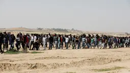Migran Afrika berkumpul berjalan menuju Penjara Saharonim untuk melakukan aksi, Israel (22/2). Otoritas Israel telah memberitahukan para migran Afrika bahwa mereka punya waktu hingga Maret mendatang untuk meninggalkan Israel. (AFP Photo/Menahem Kahana)