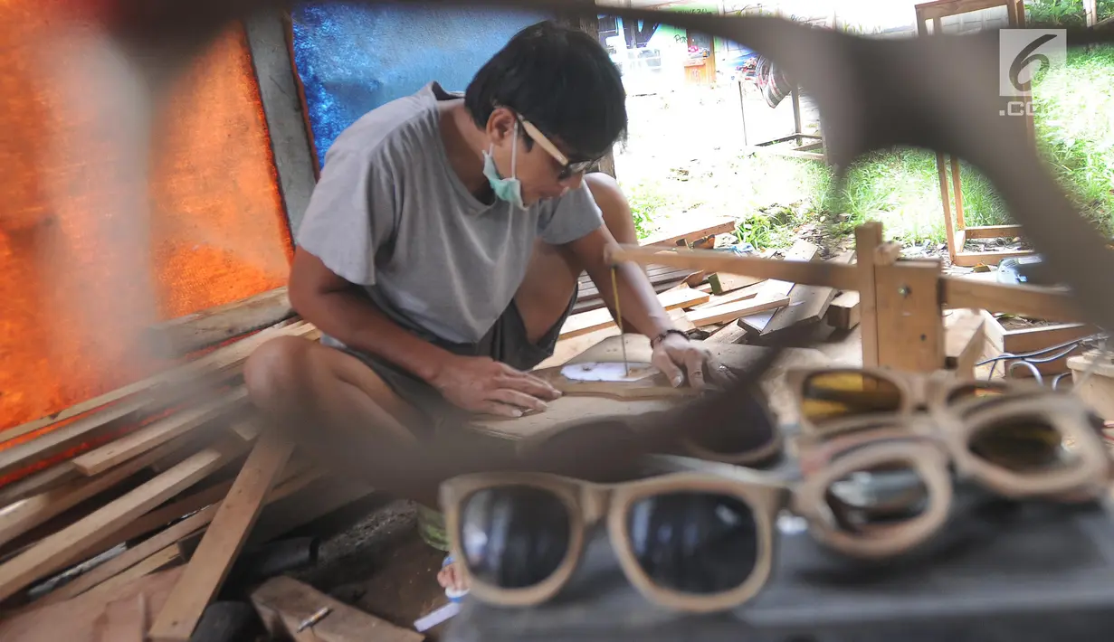 Perajin membuat kacamata berbahan baku kayu di Gang  Madrasah, Pamulang, Tangerang Selatan, Senin (21/1). Dalam sehari, pengrajin mampu menyelesaikan dua buah kacamata yang dijual antara Rp 200 ribu hingga Rp 500 ribu per buah. (Merdeka.com/Arie Basuki)