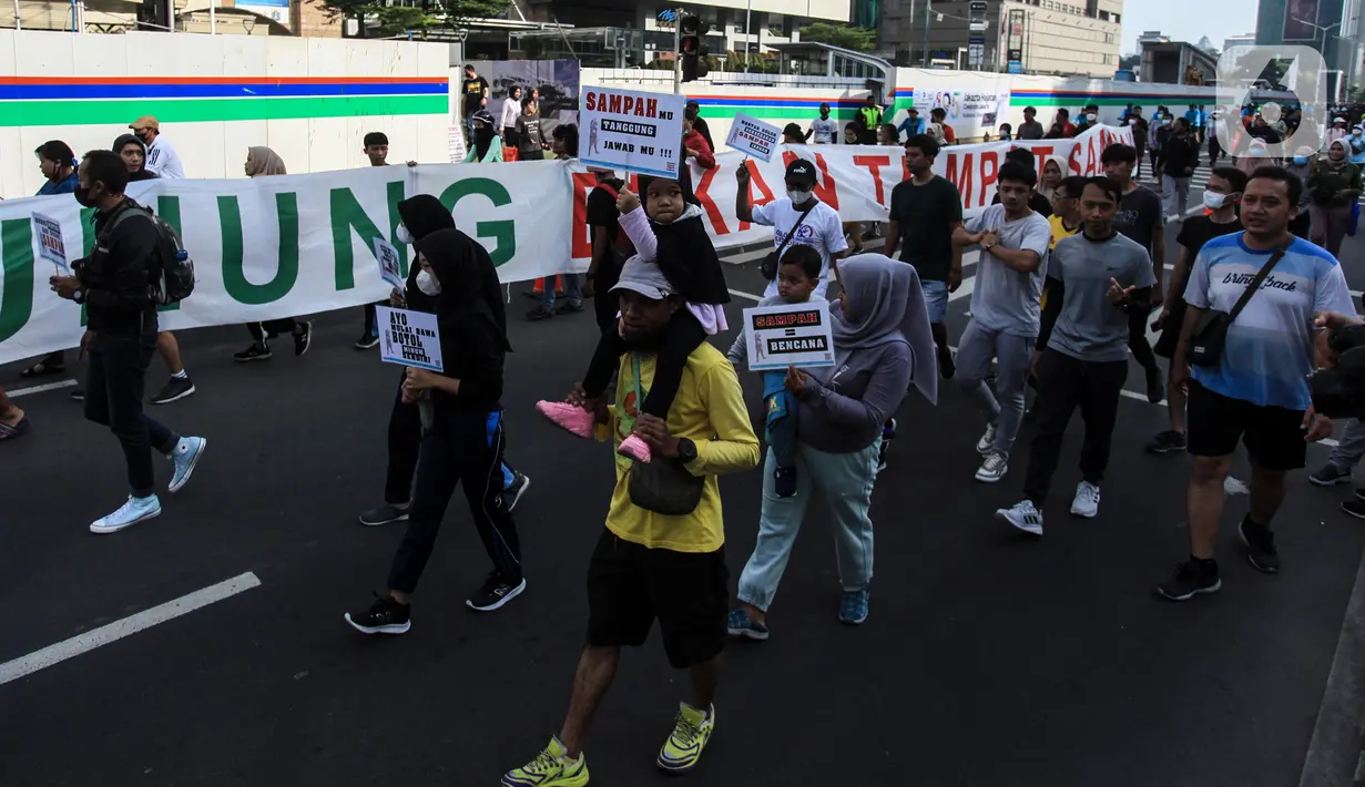 Warga dari Komunitas Peduli Sampah membawa poster aksi saat Hari Bebas Kendaraan Bermotor di Bundaran HI, Jakarta, Minggu (26/6/2022). Kampanye tentang sampah tersebut dalam rangka melanjutkan Pekan Gerakan Jakarta Sadar Sampah yang menghimbau masyarakat untuk saling menjaga kebersihan lingkungan. (Liputan6.com/Johan Tallo)