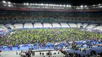 Ribuan Penonton berhamburan di lapangan stadion Stade de France saat menyaksikan pertandingan antara Prancis melawan Jerman di Saint-Denis, Paris, (13/11). Serangan bom terjadi di dekat stadion Stade de France Prancis. (AFP PHOTO/Matthieu ALEXANDRE)