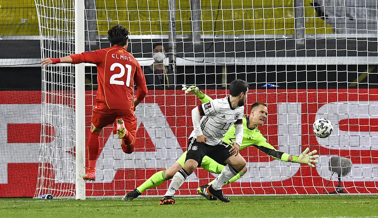 Pemain Makedonia Utara Eljif Elmas (kiri) mencetak gol ke gawang Jerman yang dijaga Marc-Andre ter Stegen pada pertandingan Grup J kualifikasi Piala Dunia 2022 di Duisburg, Jerman, Rabu (31/3/2021). Jerman kalah 1-2. (AP Photo/Martin Meissner)
