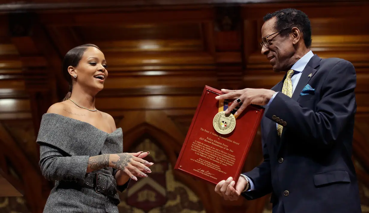 Penyanyi Rihanna (kiri) saat menerima penghargaan dari direktur Harvard Foundation, Allen Counter di Cambridge, AS, (28/2). Rihanna mendapat penghargaan Humanity of the Year Award 2017 dari Harvard University. (AP Photo/Steven Senne)
