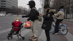 Seorang anak dengan masker melihat ke belakang di jalan Beijing, China, Jumat (2/12/2022). Lebih banyak kota melonggarkan pembatasan, memungkinkan pusat perbelanjaan, supermarket, dan bisnis lainnya dibuka kembali menyusul protes akhir pekan lalu di Shanghai dan daerah lain di mana beberapa orang menyerukan Presiden Xi Jinping untuk mengundurkan diri. (AP Photo/Ng Han Guan)