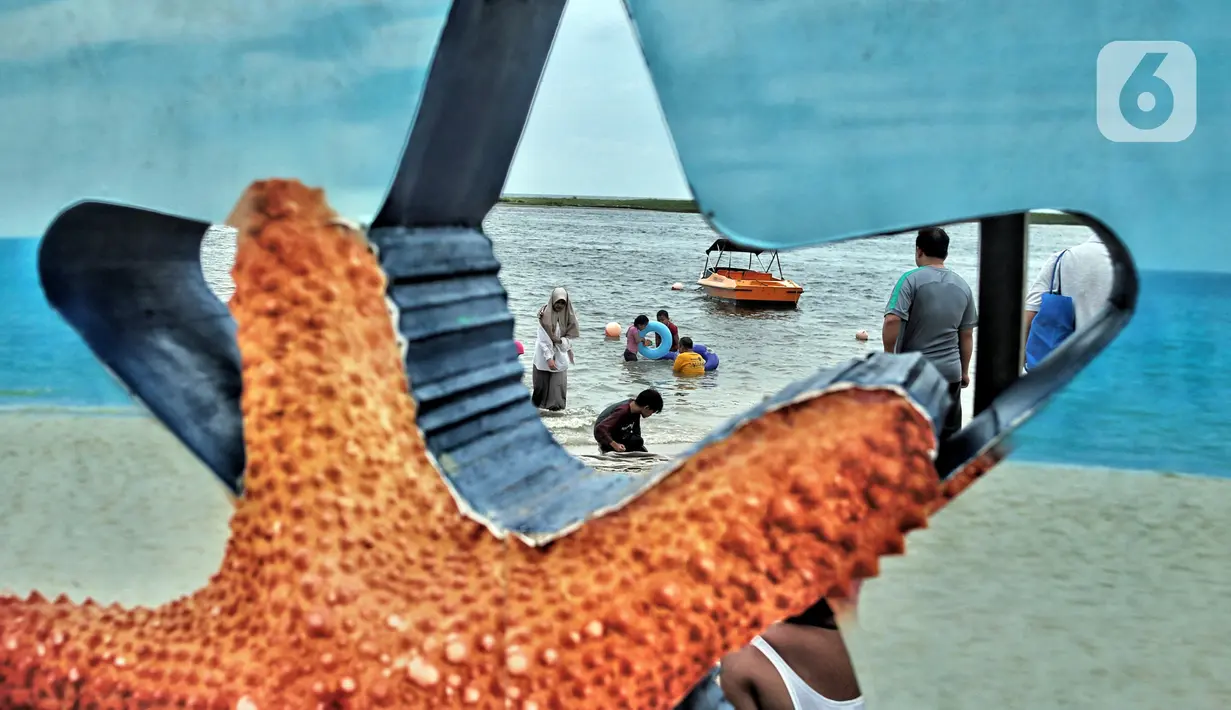 Wisatawan bermain saat mengisi libur Natal di Pantai Ancol, Jakarta, Minggu (25/12/2022). Kepala Komunikasi PT Pembangunan Jaya Ancol Ariyadi Eko Nugroho mengungkapkan per hari ini jumlah wisatawan di Taman Impian Jaya Ancol tembus 40.000, angka tersebut meningkat dua kali lipat dibanding libur hari biasa maupun Natal tahun 2021. (merdeka.com/Iqbal S. Nugroho)