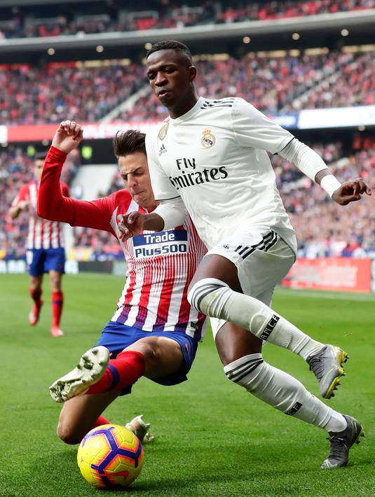 Striker Real Madrid, Vinicius Junior berusaha melewati Bek Atletico Madrid, Santiago Arias selama pertandingan lanjutan La Liga Spanyol di stadion Wanda Metropolitano (9/2). Real Madrid menang 3-1 atas Atletico. (AP Photo/Manu Fernandez)