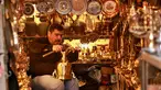 Pedagang barang antik Saadoun Mansouri bekerja di tokonya di Baghdad, Irak, Rabu (20/3). (AP Photo/Hadi Mizan)