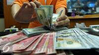 Petugas menghitung uang pecahan US$100 di pusat penukaran uang, Jakarta, , Rabu (12/8/2015). Reshuffle kabinet pemerintahan Jokowi-JK, nilai Rupiah terahadap Dollar AS hingga siang ini menembus Rp 13.849. (Liputan6.com/Johan Tallo)