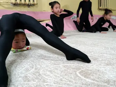 Seorang anak berlatih gerakan lentur di sebuah sekolah pelatihan di Ulaanbaatar, Mongolia, 4 Juli 2016. Sekolah di Mongolia ini mengajarkan gerakan-gerakan lentur yang hanya bisa dilakukan oleh orang tertentu. (REUTERS / Natalie Thomas)