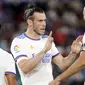 Los Blancos membuka kedudukan terlebih dahulu lewat gol cepat Gareth Bale (kiri) ketika babak pertama baru berjalan lima menit. Bale sukses menuntaskan umpan Benzema meski dirinya dikawal oleh dua pemain. Papan skor berubah menjadi 1-0 atas keunggulan Real Madrid. (Foto: AP/Alberto Saiz)