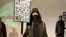 Seorang model membawa poster saat presentasi karya Robert James dalam New York Fashion Week (NYFW) di New York,AS  (30/1). Poster ini menyindir Wakil Presiden Mike Pence yang anti-aborsi. (Robin Marchant Getty Images/AFP)