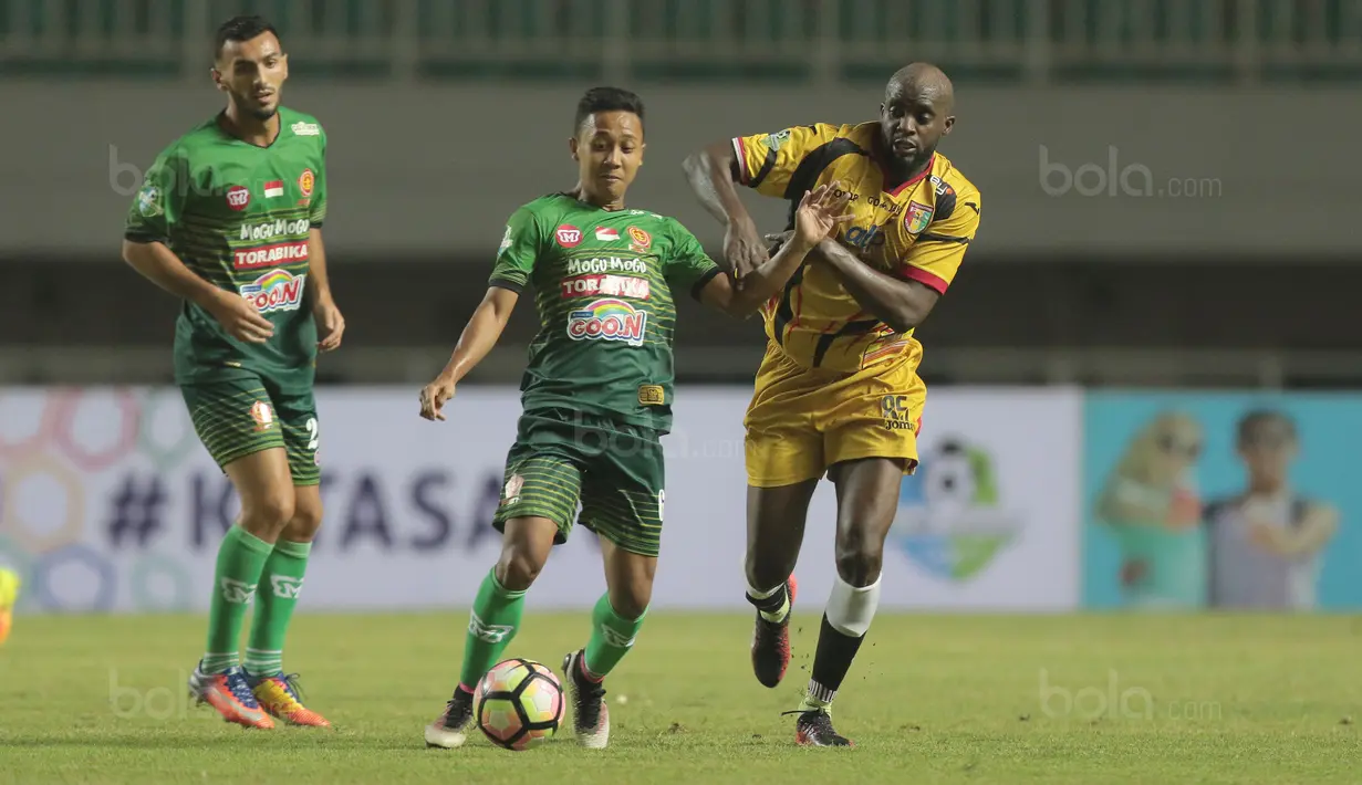 Pemain PS TNI, Roni Ariyanto (tengah) berebut bola dengan pemain Mitra Kukar, Mohammed Sissoko pada lanjutan Liga 1 2017 di Stadion Pakansari, Bogor (26/9/2017). PS TNI menang 2-1. (Bola.com/Nicklas Hanoatubun)