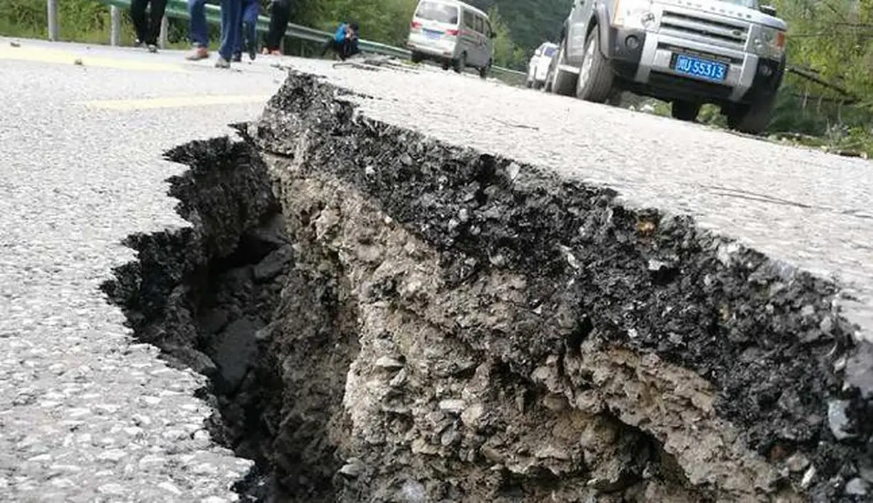 Jalanan yang terbelah yang disebabkan gempa di sebuah jalan di Jiuzhaigou di provinsi Sichuan barat daya China (9/8). Sedikitnya 12 orang tewas ketika sebuah gempa berkekuatan 6,5 skala Richter melanda China barat day. (AFP Photo/Str/China Out)