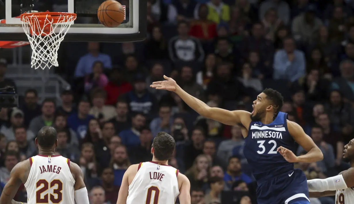 Pemain Minnesota Timberwolves, Karl-Anthony Towns (kiri) melakukan lays up melewati pemain Cleveland Cavaliers, LeBron James (kiri)  pada laga NBA basketball game di Target Center, Minneapolis, (8/1/2018). Minnesota menang 127-99. (AP/Jim Mone)