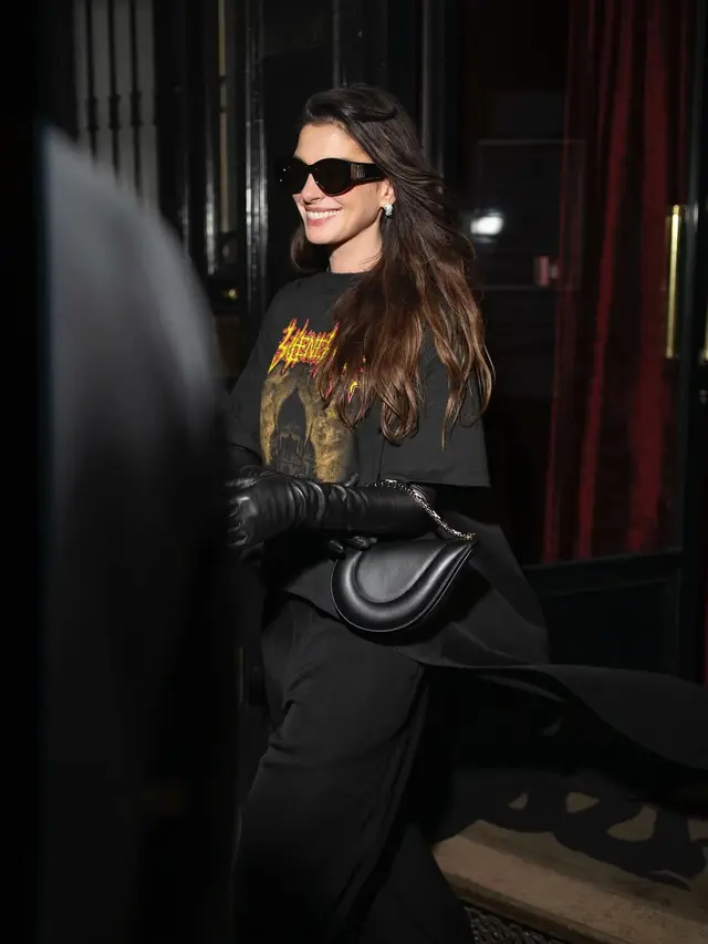 Gaya Slay Anne Hathaway dengan Kaos Oblong Hadiri Show Balenciaga di Paris Fashion Week