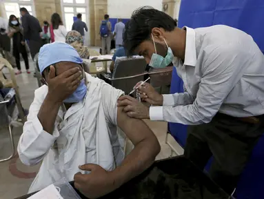 Seorang pria lanjut usia (lansia) bereaksi saat menerima vaksin virus Corona Sinopharm di pusat vaksinasi di Karachi, Pakistan, Rabu (10/3/2021). Pakistan telah mulai memvaksinasi orang yang berusia 60 tahun ke atas untuk melindungi mereka dari COVID-19 (AP Photo/Fareed Khan)