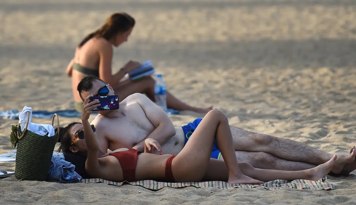 Dua turis berselfie di pantai Nha Trang di provinsi Khanh Hoa (21/8/2019). Kota ini mempunyai sekitar 392.000 penduduk, angka yang diproyeksikan meningkat menjadi antara 560.000 pada tahun 2015 dan 630.000 penduduk pada tahun 2025. (AFP Photo/Nhac Nguyen)