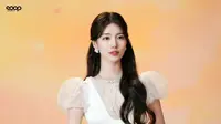 Rambut panjang bergelombangnya dibiarkan terurai lembut, dengan sebagian ditata ke atas untuk menciptakan volume yang pas.  [@skuukzky/@management_soop].