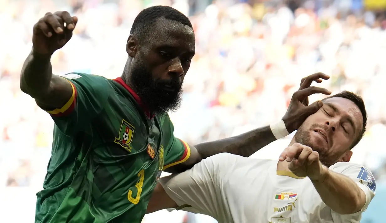 Bek Kamerun Nicolas Nkoulou berebut bola dengan gelandang Andrija Zivkovic pada matchday 2 Grup G Piala Dunia 2022 di Al Janoub Stadium, Senin (28/11/2022). Dua gol beruntun dari Vincent Aboubakar dan Eric Maxim Choupo-Moting membuat skor menjadi 3-3. (AP Photo/Francisco Seco)
