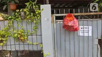 Bantuan bahan pokok kepada pasien positif Covid-19 yang melakukan isolasi mandiri di rumahnya terlihat di pagar di RT03/RW03, Kelurahan Cilangkap, Jakarta, Jumat (21/5/2021). (Liputan6.com/Herman Zakharia)