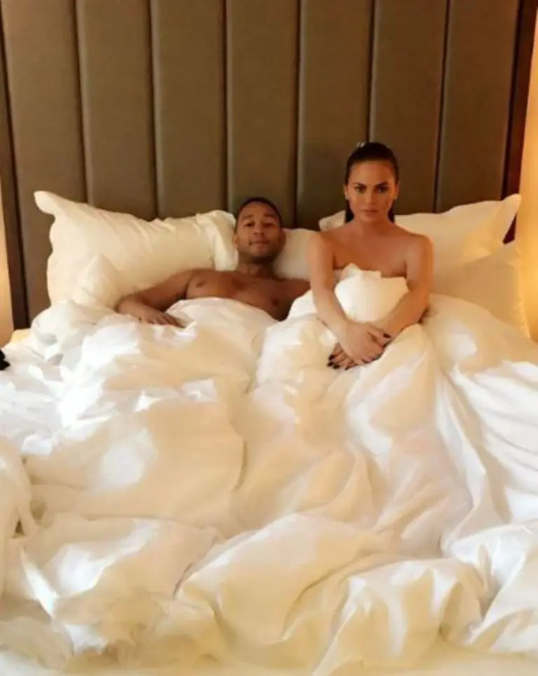 Chrissy Teigen pose bareng suaminya, John Legend di atas ranjang. [foto: instagram/chrissyteigen]