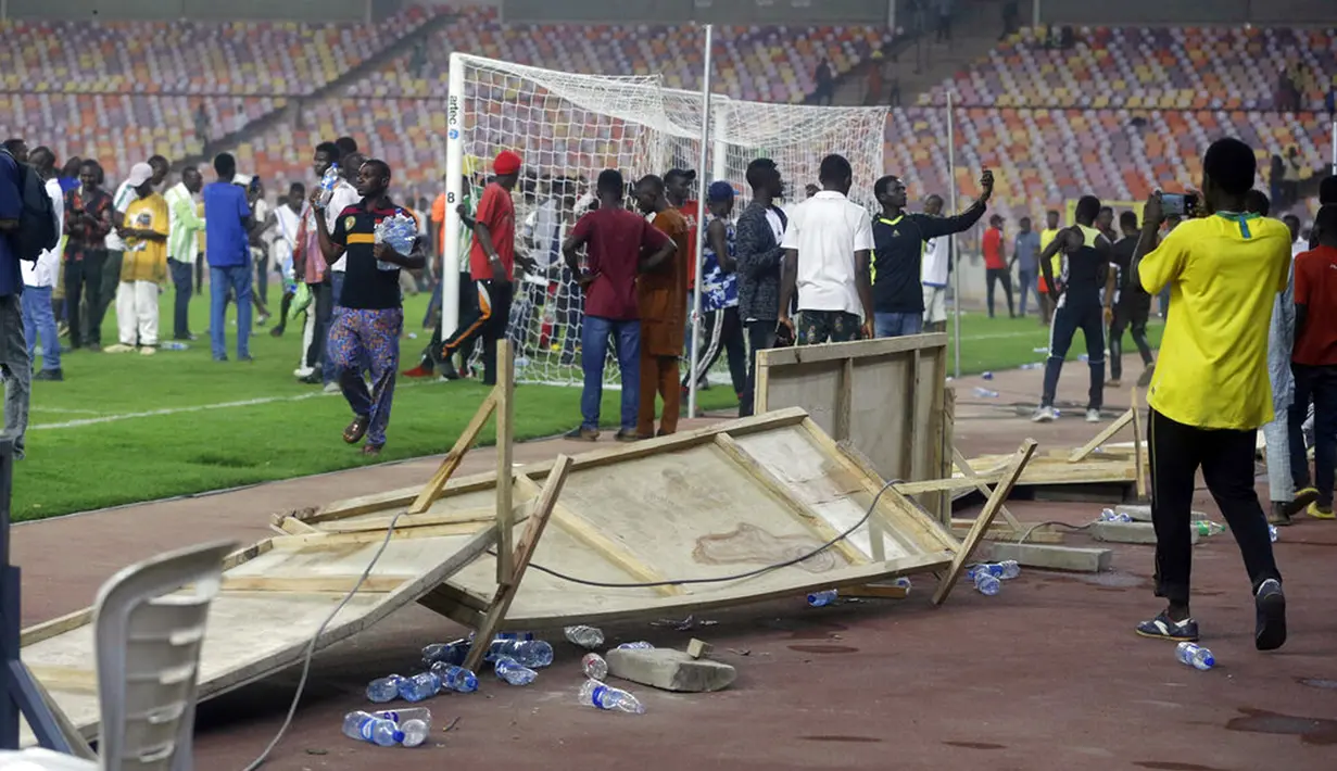 Polisi menembakkan gas air mata untuk mengeluarkan penonton dari lapangan pada akhir pertandingan kualifikasi Piala Dunia 2022 antara Ghana Vs Nigeria di Stadion Moshood Abiola, Abuja, Nigeria, 29 Maret 2022. Fans Nigeria ngamuk setelah gagal lolos ke Piala Dunia 2022. (AP Photo/Sunday Alamba)