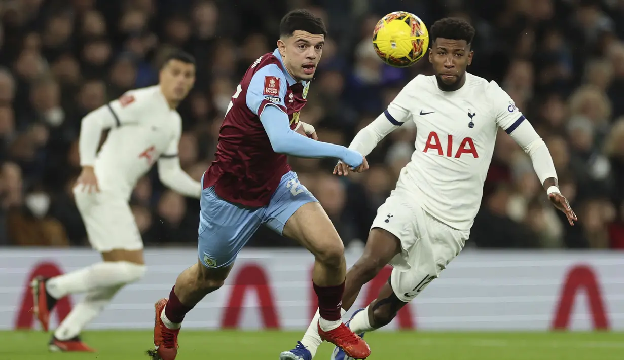 Striker Burnley, Zeki Amdouni (kiri) berebut bola dengan bek Tottenham Hotspur, Emerson Royal pada laga putaran ketiga Piala FA 2023/2024 di Tottenham Hotspur Stadium, London, Sabtu (6/1/2024) dini hari WIB. (AP Photo/Ian Walton)