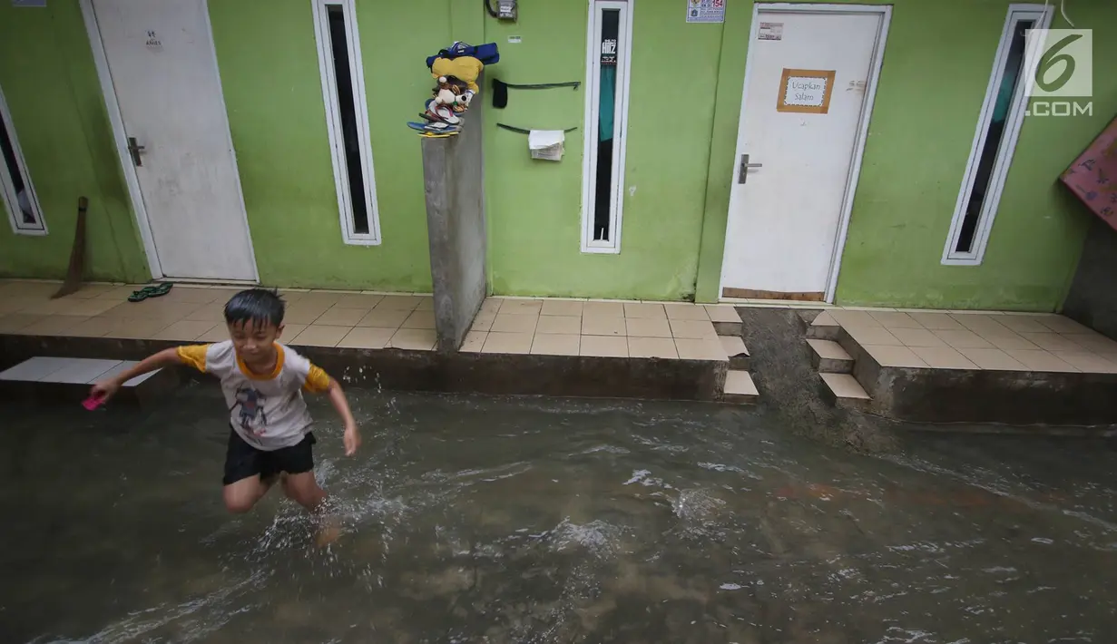 Seorang anak bermain air banjir di kawasan Jatipadang, Jakarta, Rabu (22/11). Jebolnya tanggul Kali Pulo di kawasan tersebut menyebabkan puluhan rumah terendam banjir. (Liputan6.com/Immanuel Antonius)