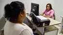 Petugas medis, Francia Papamija sedang menerima konsultasi seorang pasien di sebuah rumah sakit di Cali, Kolombia (14/11). Petugas tunanetra ini menjadi bagian dari proyek "Hands That Save Lives". (AFP/Luis Robayo)