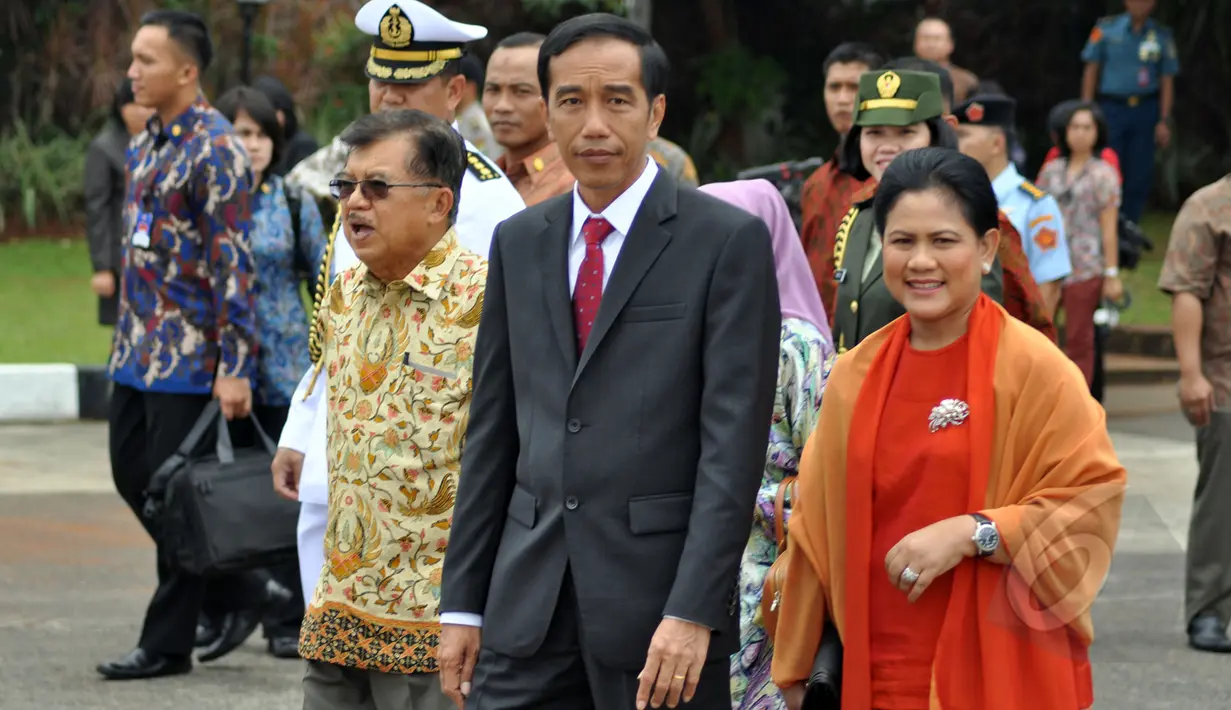 Presiden Jokowi (tengah) dan Ibu Negara, Iriana (kanan) didampingi Wapres Jusuf Kalla (kiri) berjalan menuju pesawat kepresidenan untuk memulai kunjungan kenegaraan di Bandara Halim Perdanakusuma, Jakarta, Minggu (22/3/2015). (Liputan6.com/Faizal Fanani)