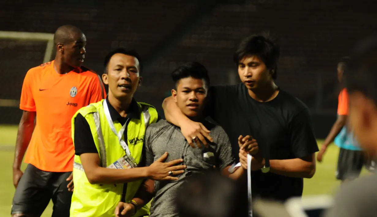 Salah satu suporter Juventus terpaksa diamankan pihak keamanan akibat berulah masuk lapangan di Stadion GBK, Jakarta, (5/8/2014). (Liputan6.com/Helmi Fithriansyah) 