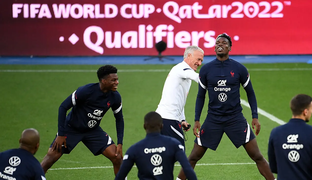 Pelatih Timnas Prancis Didier Deschamp bercanda dengan Paul Pogba (kanan) dan Fance Aurelien Tchouameni saat sesi latihan di stadion Olimpiade di Kiev, Jumat (3/9/2021). Prancis akan menghadapi Ukraina dalam lanjutan Kualifikasi Piala Dunia 2022 Minggu dinihari, 5 September 2021. (FRANCK FIFE/AFP)