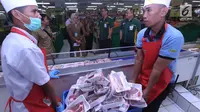 Dua pekerja mengangkat daging saat Disperindag Kota Tangerang Selatan melakukan sidak pasar jelang Ramadan di sejumlah wilayah pasar dan supermarket kawasan BSD, Selasa (15/5). (Merdeka.com/Arie Basuki)