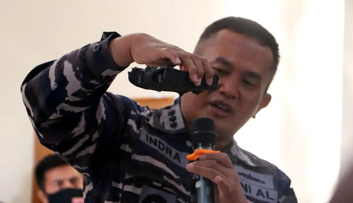 Perwira TNI Angkatan Laut memperlihatkan bagian dari sistem torpedo yang ditemukan dalam operasi pencarian kapal selam KRI Nanggala 402 di Pangkalan Udara Militer Ngurah Rai, Bali, Sabtu (24/4/2021). KRI Nanggala 402 dinyatakan tenggelam atau subsunk. (HANDOUT/INDONESIAN MILITARY/AFP)