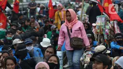 Pedagang asongan berjualan di tengah-tengah aksi unjuk rasa di kawasan Patung Kuda, Jakarta, Selasa (10/11/2020). Sejumlah pedagang mencoba peruntungan saat massa gabungan dari berbagai organisasi buruh dan mahasiswa berunjuk rasa menolak Omnibus Law UU Cipta Kerja. (Liputan6.com/Helmi Fithriansyah)