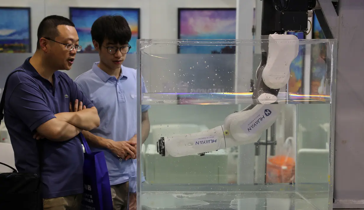 Dua pria melihat robot yang digunakan dalam operasi bawah laut selama China International Robot Show di Shanghai (10/7/2019). Pameran yang menghadirkan robot-robot canggih ini diselenggarakan dari 10 sampai 13 Juli 2019. (AFP Photo/STR)