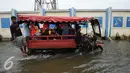 Sejumlah warga menumpang gerobak motor melitasi banjir di Kawasan Muara Angke, Jakarta, Rabu (11/1). Sejak jebolnya tanggul sampai saat ini tidak ada perbaikan yang dilakukan pemerintah pusat dan daerah. (Liputan6.com/Gempur M. Surya)