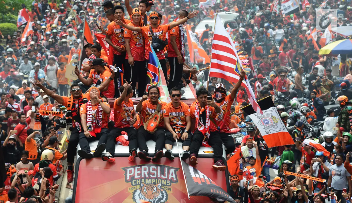 Pemain dan official Persija duduk di atas bus saat konvoi atas kemenangan di  Liga 1, Jalan MH Thamrin, Jakarta, Sabtu (15/12). Mereka akan menyerahkan piala Liga 1 kepada Gubernur DKI Jakarta Anis Baswedan. (Merdeka.com/Imam Buhori)