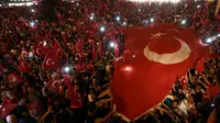 Pendukung Presiden Turki, Tayyip Erdogan mengibarkan bendera nasional mereka ketika berkumpul di Taksim Square, pusat kota Istanbul, Sabtu (16/7). Ratusan warga turun ke jalan untuk merayakan kegagalan kudeta militer di Turki. (REUTERS/Huseyin Aldemir)