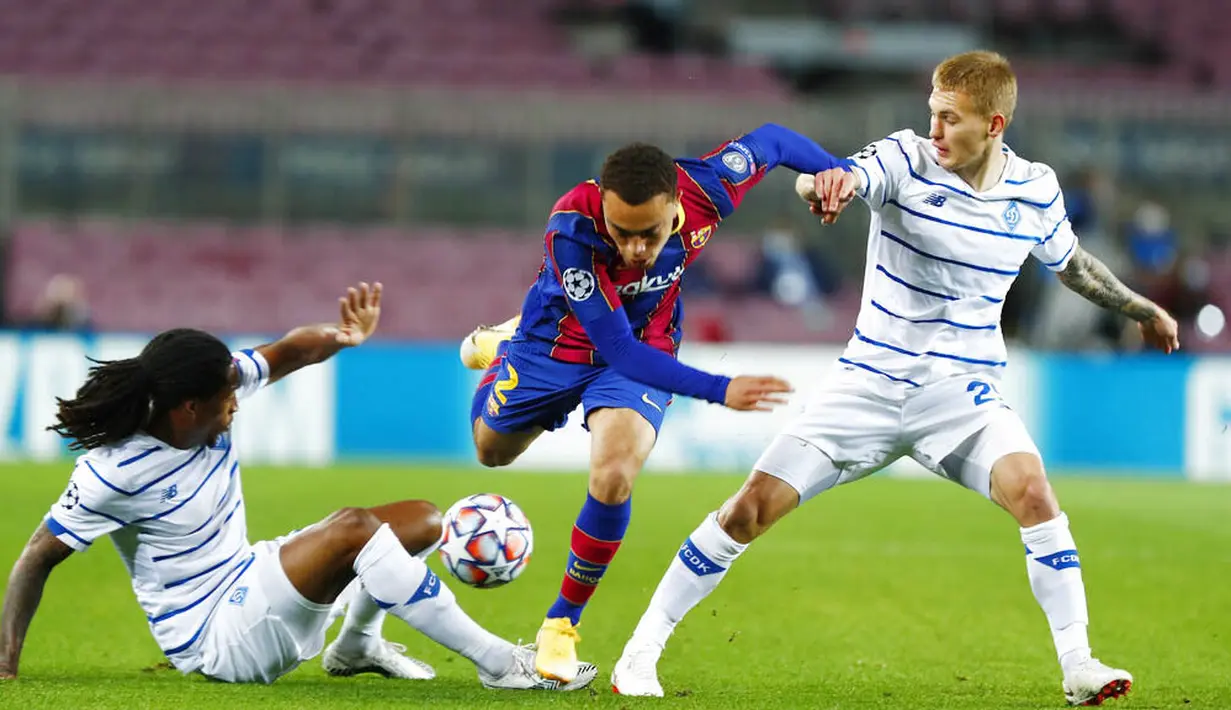 Pemain Barcelona, Sergino Dest, berusaha melewati pemain Dynamo Kiev pada laga Liga Champions di Stadion Camp Nou, Kamis (5/11/2020). Barcelona menang dengan skor 2-1. (AP/Joan Monfort)