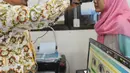 Petugas memindai retina seorang warga saat pembuatan E-KTP di Kantor kelurahan Cinere, Depok, Kamis (27/12). Hari ini Disdukcapil daerah melaksanakan pelayanan jemput bola perekaman E-KTP serentak khusus pemula secara nasional. (Merdeka.com/Arie Basuki)